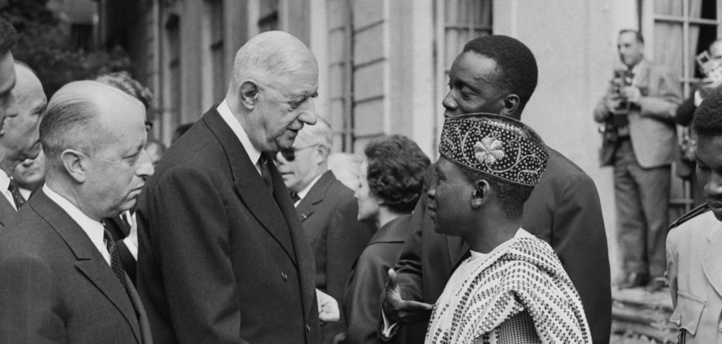 A picture released on July 12, 1963, of then-French President Gen. Charles de Gaulle (2L) and Jacques Foccart (L) greeting African, Malagasy and French overseas territories veterans arriving in Paris for French Bastille Day celebrations.