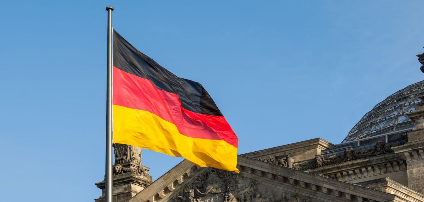 A German flag flutters in front of the Reichstag building in Berlin, Germany. A German flag flutters in front of the Reichstag building in Berlin, Germany.