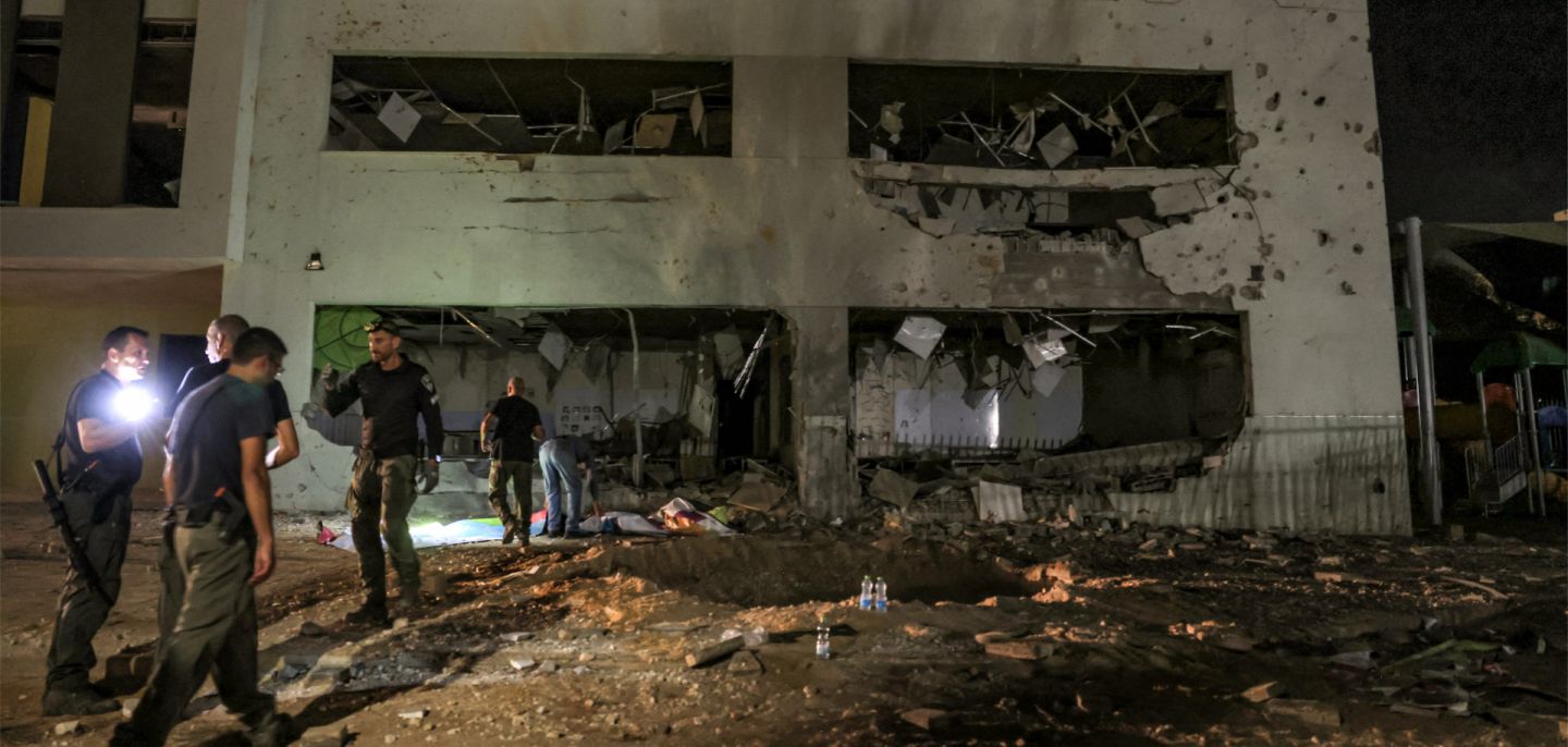 Authorities in Israel's southern city of Gedera assess a damaged school building after a projectile exploded upon impact on Oct. 1, 2024, after Iran launched a barrage of missiles at Israel. Authorities in Israel's southern city of Gedera assess a damaged school building after a projectile exploded upon impact on Oct. 1, 2024, after Iran launched a barrage of missiles at Israel.