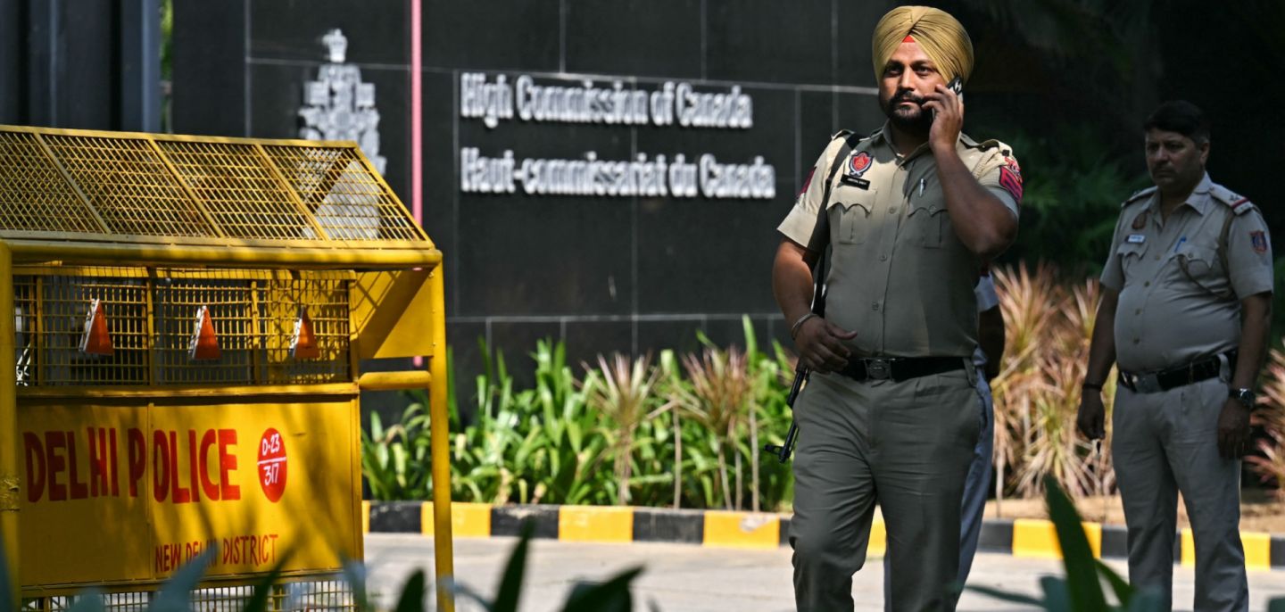 Indian policemen stand guard outside the entrance of the High Commission of Canada in New Delhi on Oct. 15, 2024. 