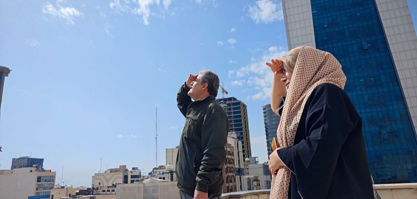 People in Tehran look to the skies from a rooftop amid reports of widespread U.S. and Israeli attacks in Iran on Feb. 28, 2026.