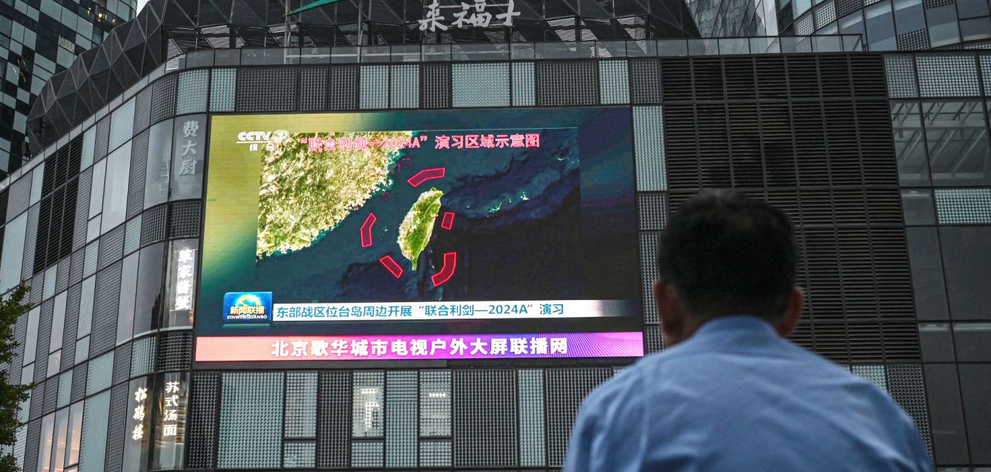 An outdoor screen shows news coverage of China's military drills around Taiwan, in Beijing, China, on May 23, 2024. 