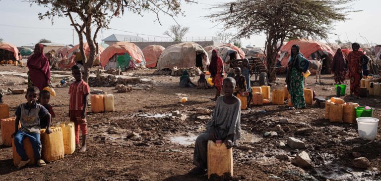 People wait for water with containers at a camp for internally displaced persons (IDPs) in Baidoa, Somalia, on Feb. 13, 2022. People wait for water with containers at a camp for internally displaced persons (IDPs) in Baidoa, Somalia, on Feb. 13, 2022.
