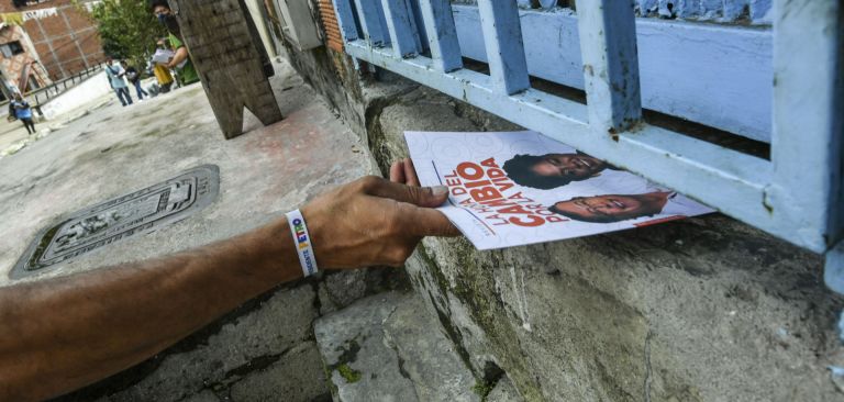 A volunteer slides a flyer into a house in Medellin, Colombia, supporting left-wing presidential candidate Gustavo Petro on May 27, 2022. A volunteer slides a flyer into a house in Medellin, Colombia, supporting left-wing presidential candidate Gustavo Petro on May 27, 2022.Â