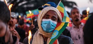A woman holds a candle during a memorial service for the victims of the Tigray conflict in Addis Ababa, Ethiopia, on Nov. 3, 2021. 
