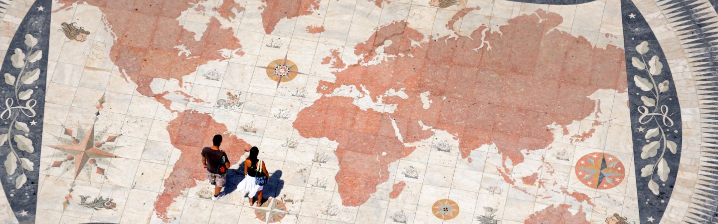 Pedestrians stand on top of a world map at a monument commemorating the Age of Exploration in Lisbon, Portugal. Pedestrians stand on top of a world map at a monument commemorating the Age of Exploration in Lisbon, Portugal.