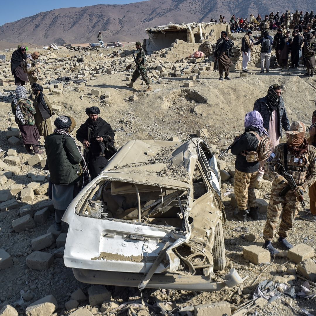 Taliban security personnel inspect a car damaged by Pakistani air strikes in Afghanistan's eastern Paktika province on Dec. 26, 2024. 