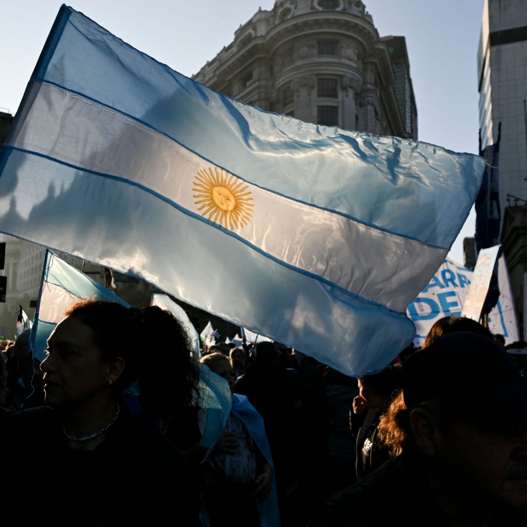 Anti-government protesters hold up the Argentine flag during a rally outside the presidential palace in Buenos Aires on July 9, 2022. Anti-government protesters hold up the Argentine flag during a rally outside the presidential palace in Buenos Aires on July 9, 2022.