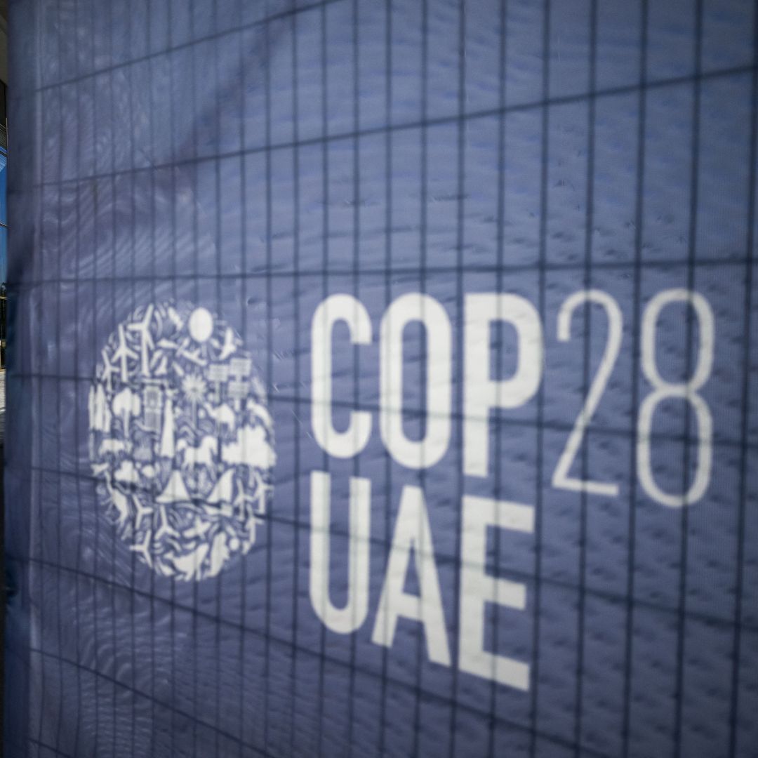 A man walks past a COP28 sign at the venue of the U.N. climate summit in Dubai on Nov. 30, 2023. 