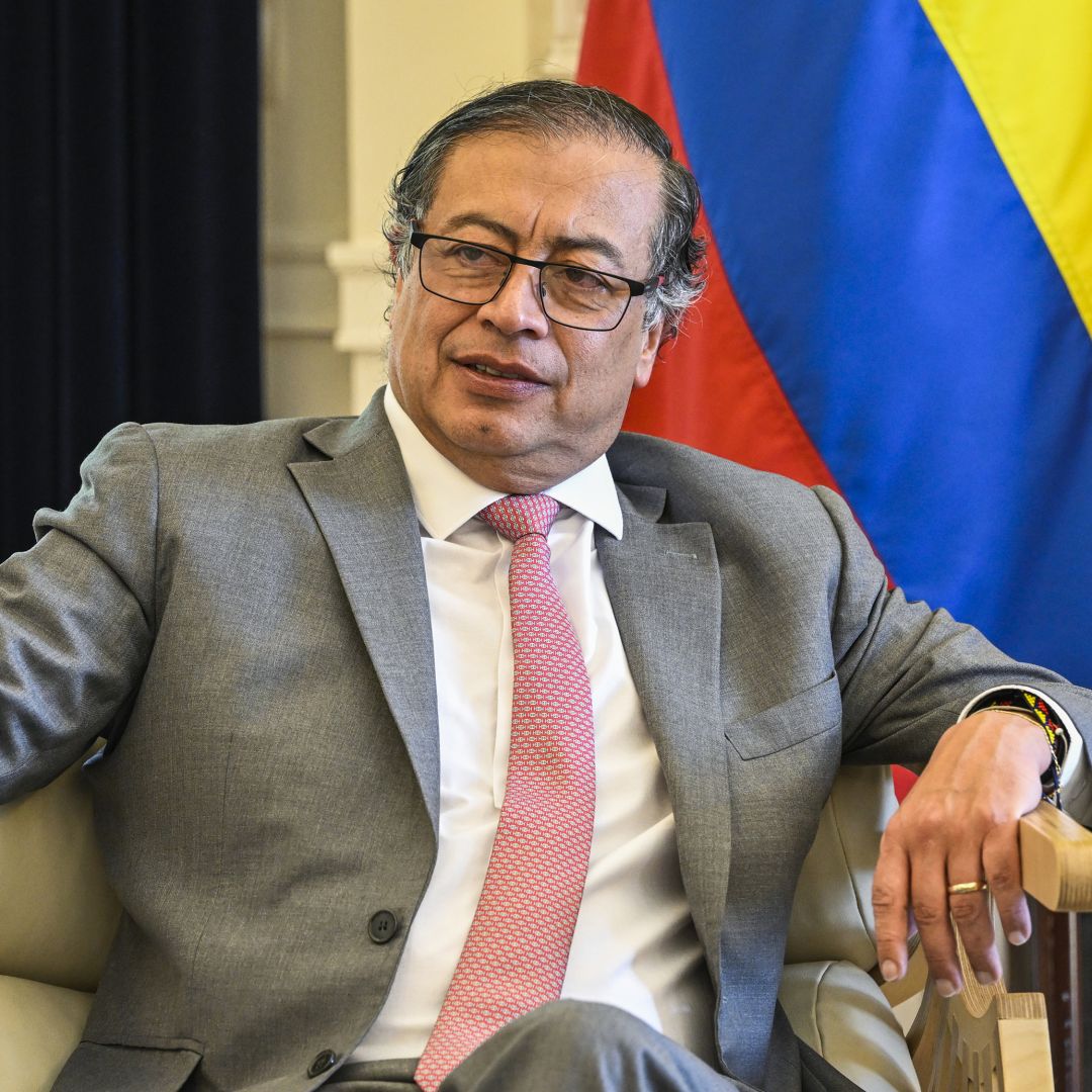 Colombian President Gustavo Petro sits in front of a Colombian flag during a meeting in Lisbon, Portugal, on May 6, 2023. 