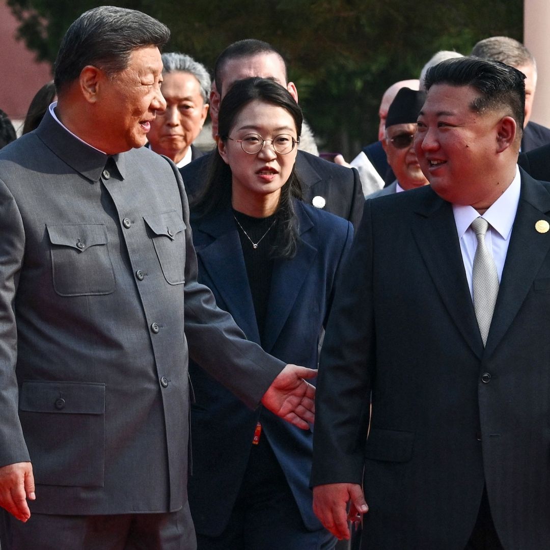 Chinese President Xi Jinping (left) gestures to North Korean leader Kim Jong Un before a military parade in Beijing's Tiananmen Square on Sept. 3, 2025.