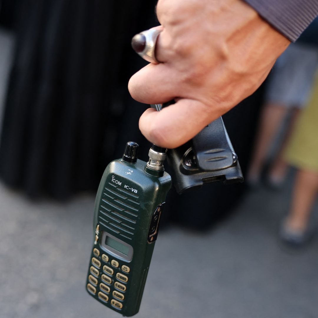 A man in Beirut, Lebanon, holds a walkie-talkie after removing its battery on Sept. 18, 2024, during a funeral for people killed when hundreds of paging devices exploded across the country the previous day. 