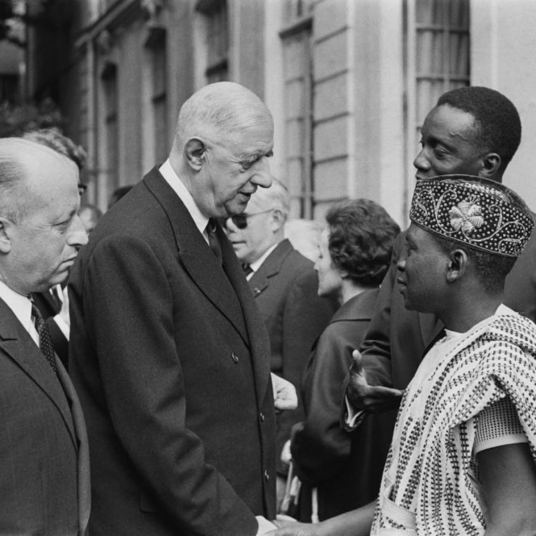 A picture released on July 12, 1963, of then-French President Gen. Charles de Gaulle (2L) and Jacques Foccart (L) greeting African, Malagasy and French overseas territories veterans arriving in Paris for French Bastille Day celebrations.