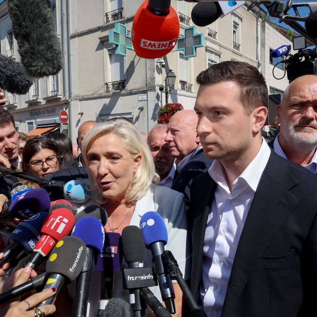 Journalists surround French far-right National Rally leader Marine Le Pen (center) as she arrives with National Rally president Jordan Bardella (third from right) for a campaign rally in La Fleche, France, on July 8, 2026. Journalists surround French far-right National Rally leader Marine Le Pen (center) as she arrives with National Rally president Jordan Bardella (third from right) for a campaign rally in La Fleche, France, on July 8, 2026.