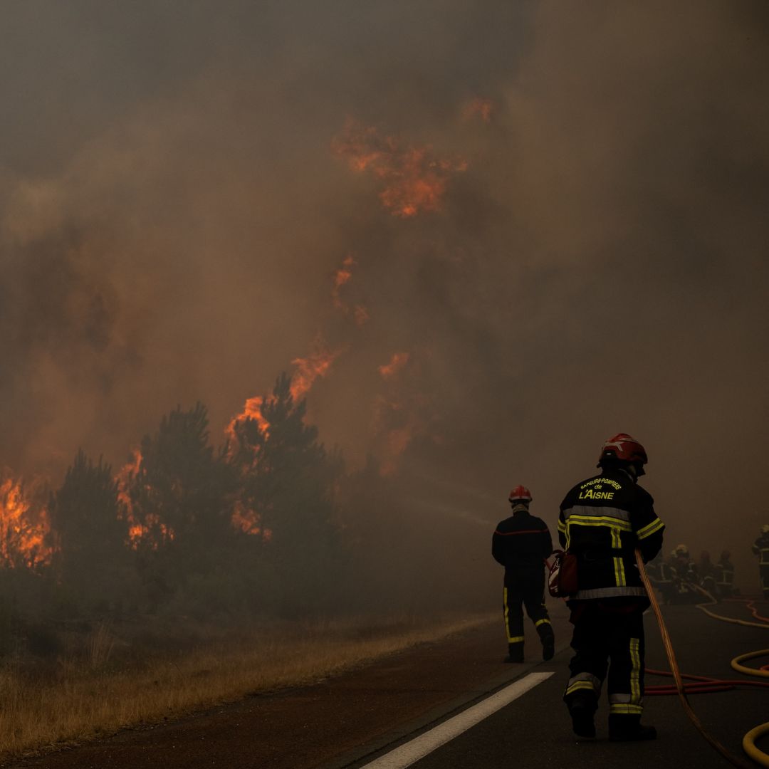 Firefighters spray water along the edge of a forest during a wildfire in southwestern France on July 25, 2026. Firefighters spray water along the edge of a forest during a wildfire in southwestern France on July 25, 2026.