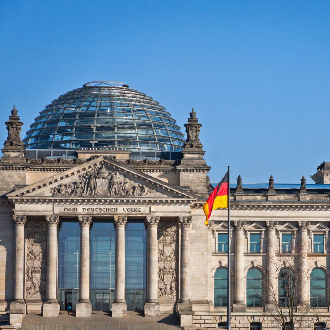 German flags are seen waving in front of the country’s parliament building in Berlin, Germany.