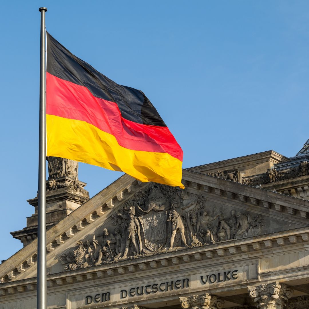 A German flag flutters in front of the Reichstag building in Berlin, Germany. 