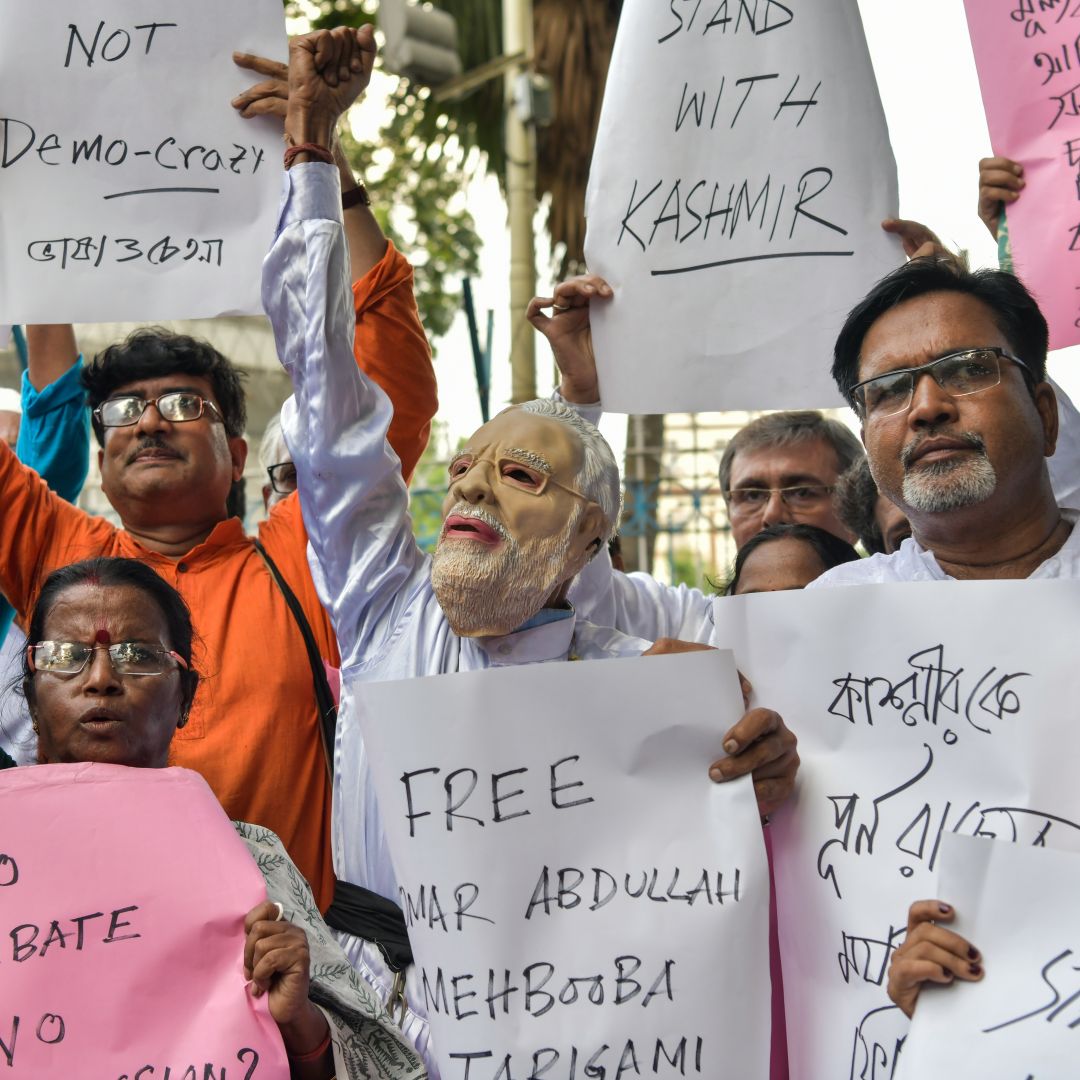 Demonstrators hold placards while shouting slogans during a protest in Kolkata on Aug. 5 at New Delhi's move to revoke Kashmir's autonomy for Jammu and Kashmir.