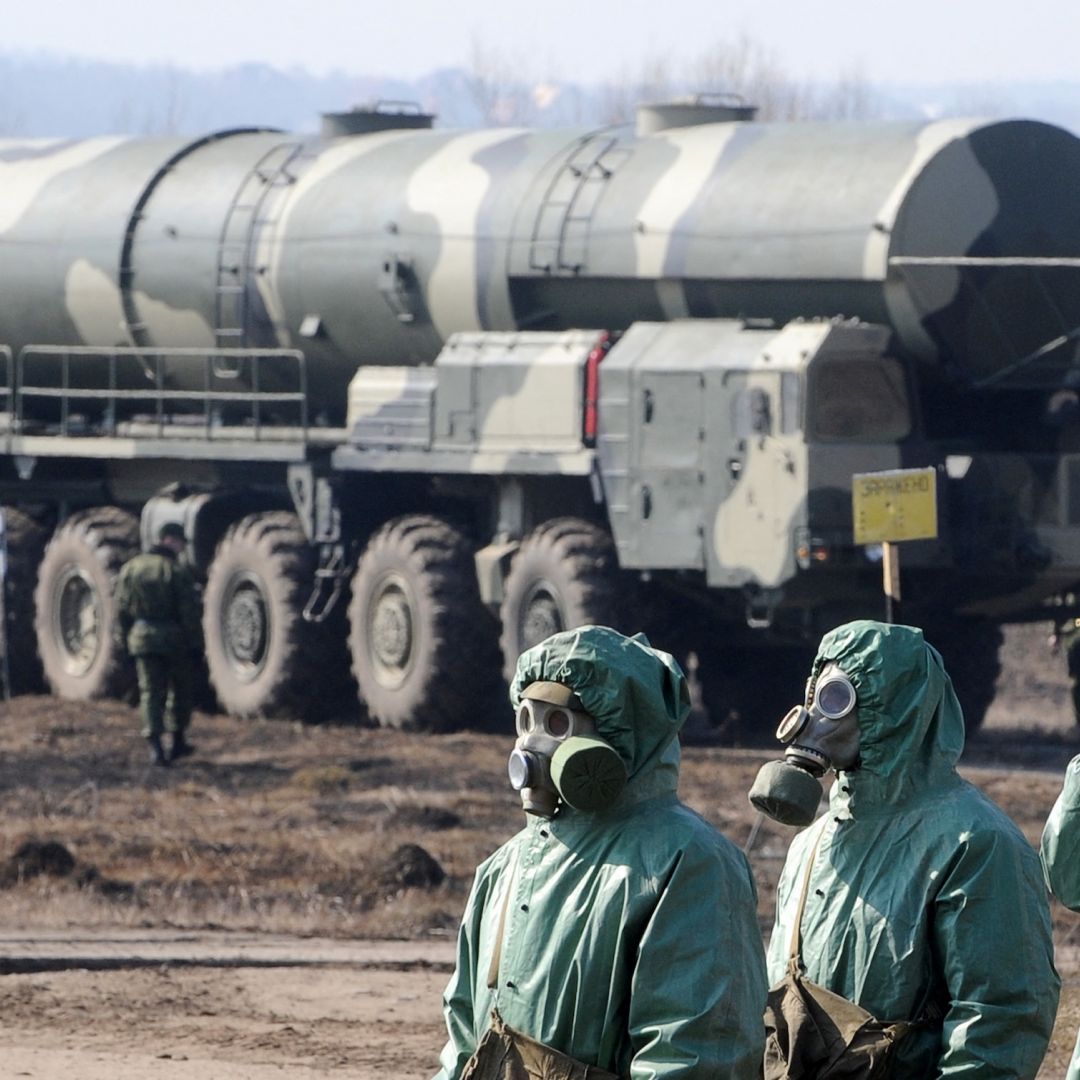 Russian soldiers wear chemical protection suits as they stand next to a military fueler on the base of a prime mover of Russian Topol intercontinental ballistic missile during a training session at the Serpukhov's military missile forces research institute some 100km outside Moscow on April 6, 2010.