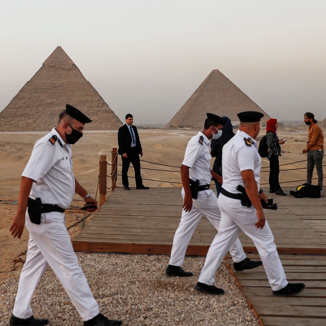 Policemen walk near an overlook at the Giza Pyramids in Egypt ahead of a ceremony commemorating the launch of the site's first environmentally-friendly bus and restaurant on Oct. 20, 2020. Policemen walk near an overlook at the Giza Pyramids in Egypt ahead of a ceremony commemorating the launch of the site's first environmentally-friendly bus and restaurant on Oct. 20, 2020.