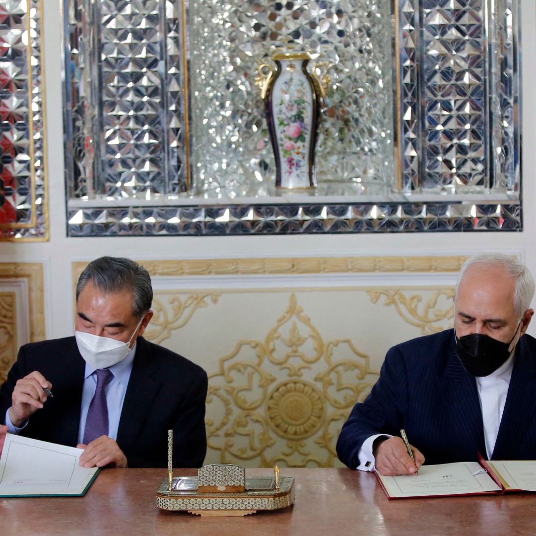 Iran and China’s foreign ministers (right to left) sign a partnership agreement in Tehran on March 27, 2021. 