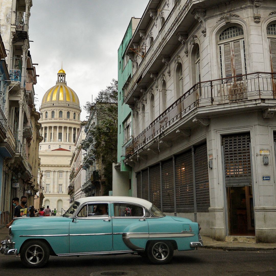 An old American car passes by the capitol building in Havana, Cuba, on May 3, 2021. 