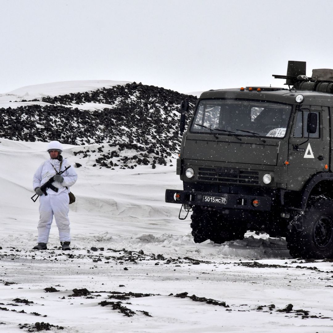 A Russian serviceman stands guard by a military truck on Alexandra Land, the largest island in Russia's Franz Josef Land archipelago in the Arctic Ocean, in May 2021.  