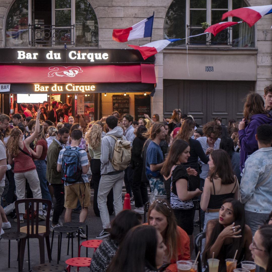 People dance in front of a bar in Paris on June 21, 2021, after the French government lifted the national curfew. 
