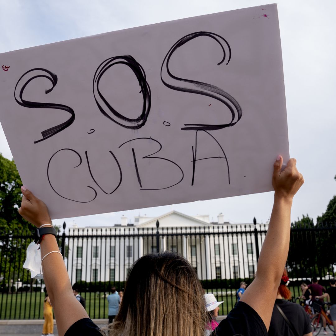 A demonstrator holds up a sign in solidarity with protesters in Cuba outside the White House on July 18, 2021. 