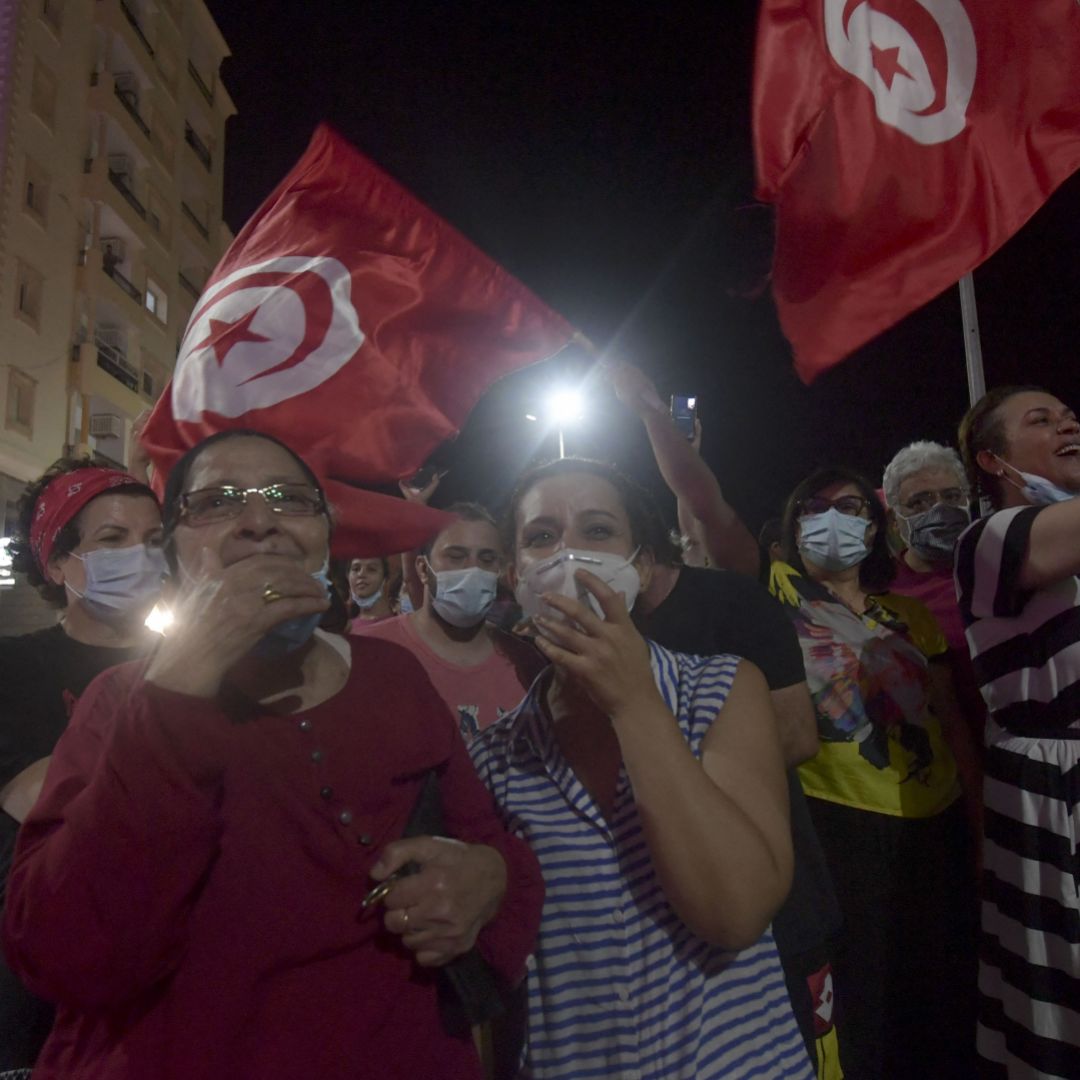 People celebrate in the streets of Tunis after Tunisian President Kais Saied announced the suspension of parliament and the dismissal of the country’s prime minister on July 25, 2021. 