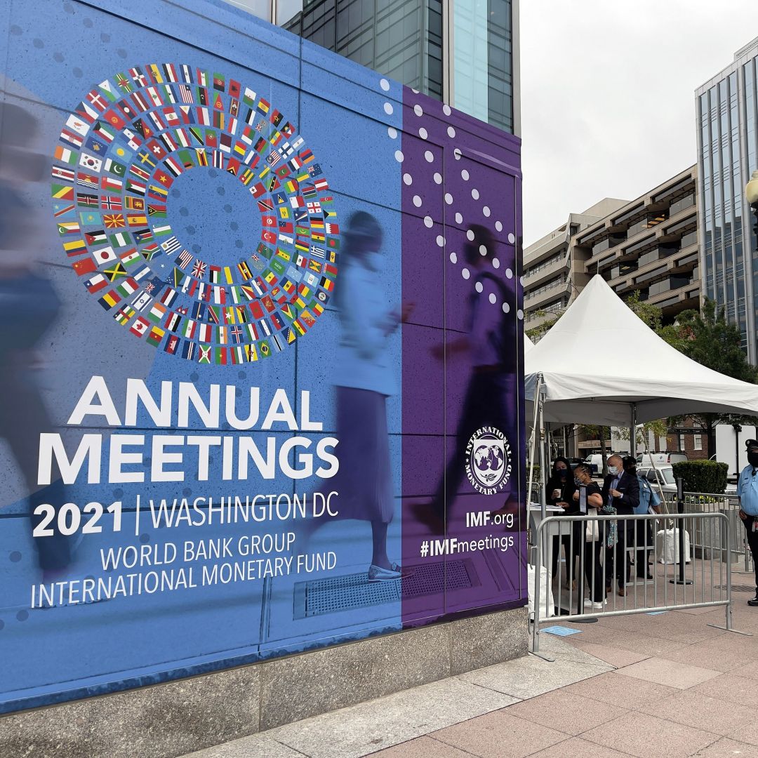 People wait outside the entrance to the annual meetings of the World Bank and International Monetary Fund (IMF) outside the IMF headquarters in Washington D.C. on Oct. 11, 2021. 
