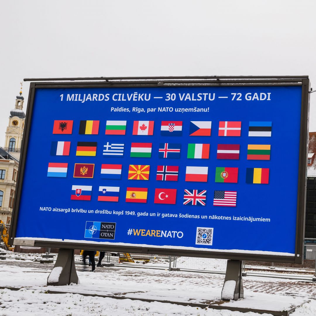 The flags of NATO member countries are seen on a billboard in Riga, Latvia, on Nov. 28, 2021, two days before the start of meetings to discuss Russia’s military buildup near Ukraine. 