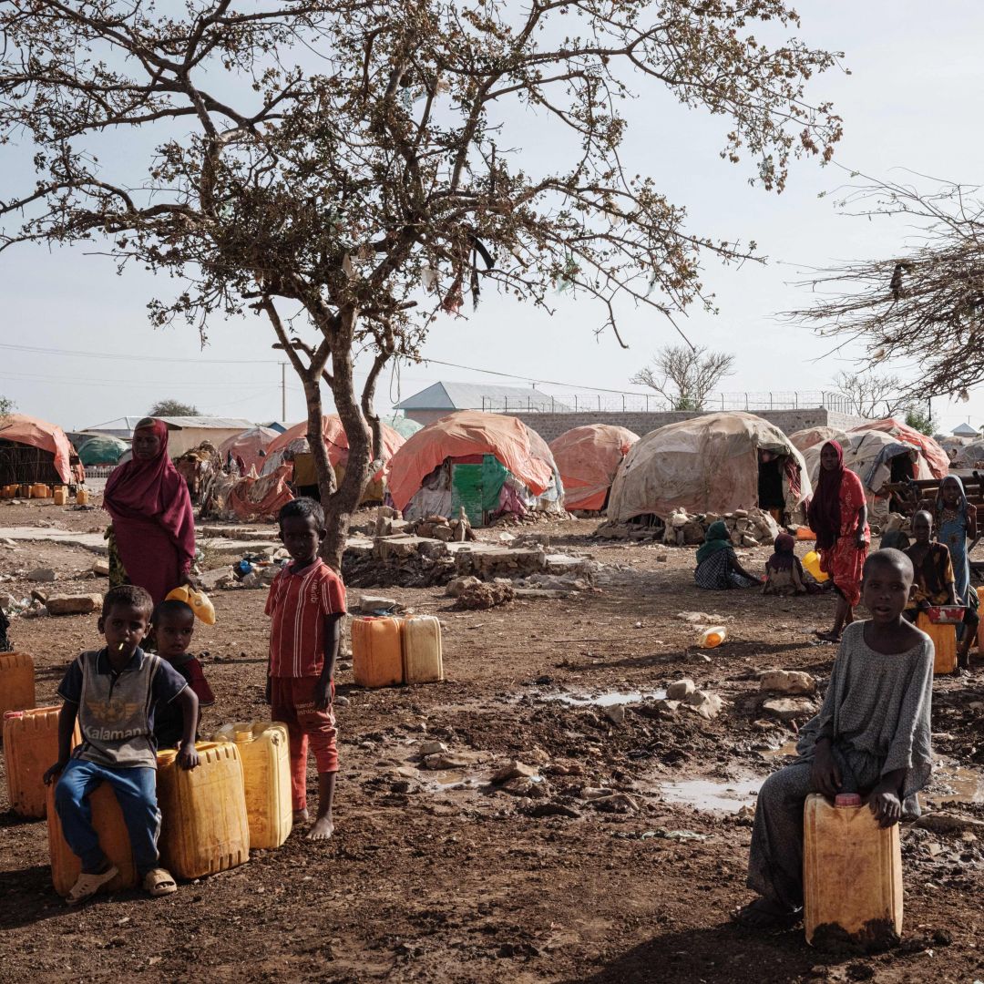 People wait for water with containers at a camp for internally displaced persons (IDPs) in Baidoa, Somalia, on Feb. 13, 2022. 