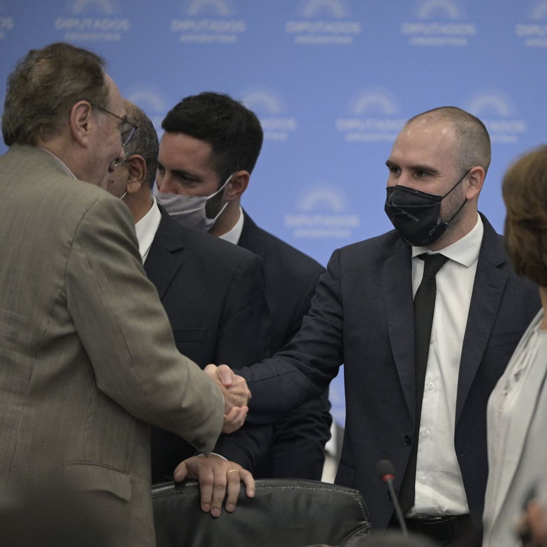 Argentina's finance minister Martin Guzman (center) shakes hands with a member of the country’s Congress in Buenos Aires before briefing legislators on the government’s new deal with the International Monetary Fund on March 7, 2022. 