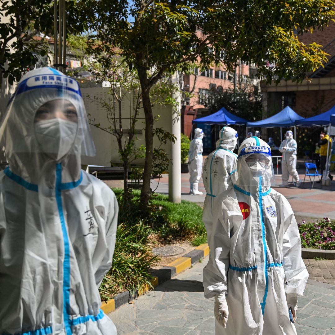 Workers are seen outside a compound where residents are being tested for COVID-19 in the Jing'an district in Shanghai, China on April 4, 2022. 