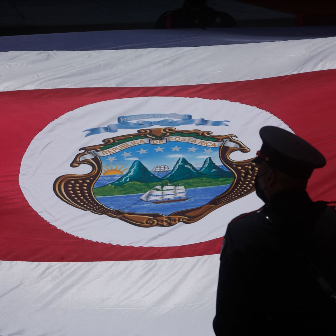 A guard stands next to a Costa Rican flag during the inauguration ceremony of the country’s new president Rodrigo Chaves in San Jose on May 8, 2022.