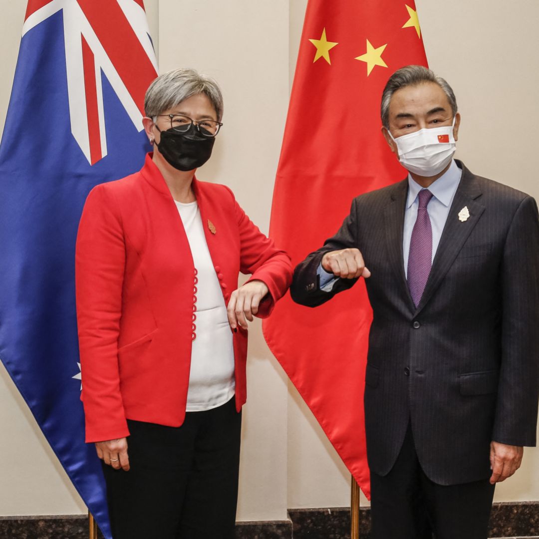 Australian Foreign Minister Penny Wong (left) bumps elbows with her Chinese counterpart Wang Yi on the sidelines of the G-20 Foreign Ministers Meeting in Bali, Indonesia, on July 8, 2022.