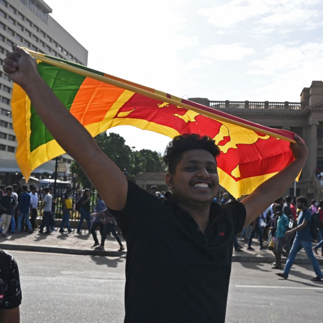 A protester waves Sri Lanka's national flag outside the presidential palace in Colombo on July 13, 2022. 