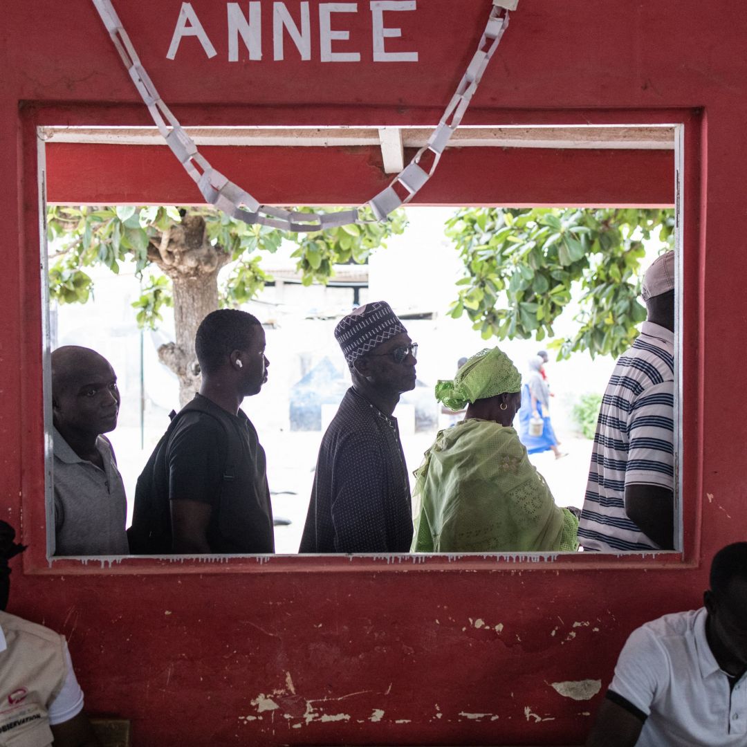People wait to vote in Senegal’s legislative election outside a polling station in Dakar on July 31, 2022.