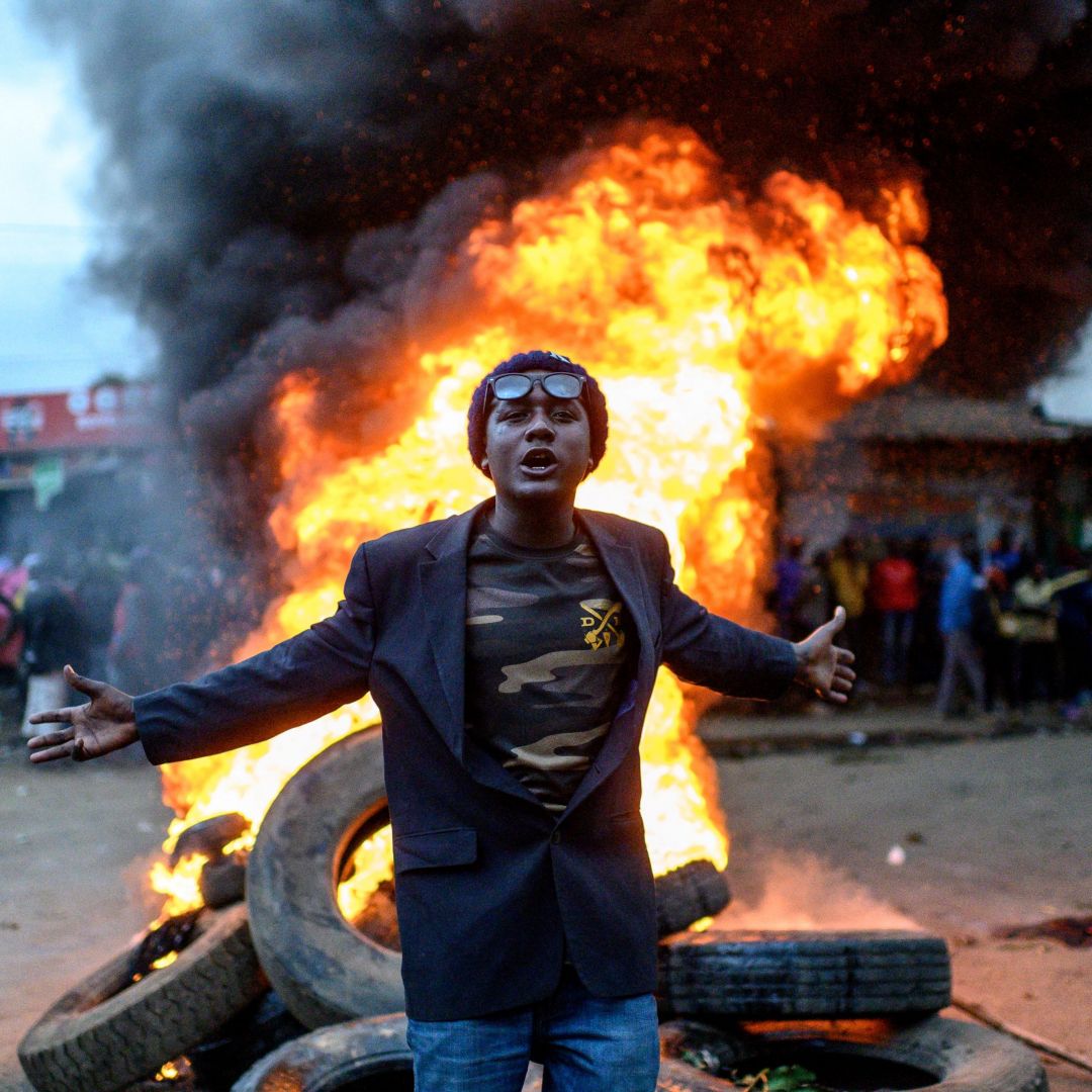 A supporter of Kenyan presidential candidate Raila Odinga gestures past a fire during a protest in Nairobi on Aug. 15, 2022, after William Ruto was declared the winner of the country's recent presidential race. A supporter of Kenyan presidential candidate Raila Odinga gestures past a fire during a protest in Nairobi on Aug. 15, 2022, after William Ruto was declared the winner of the country's recent presidential race.