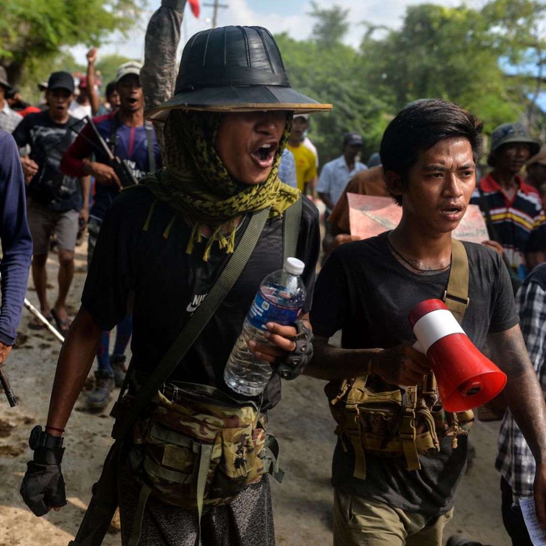 Anti-coup fighters escort protesters as they take part in a demonstration against the military coup in Sagaing, Myanmar, on Sept. 7, 2022. 