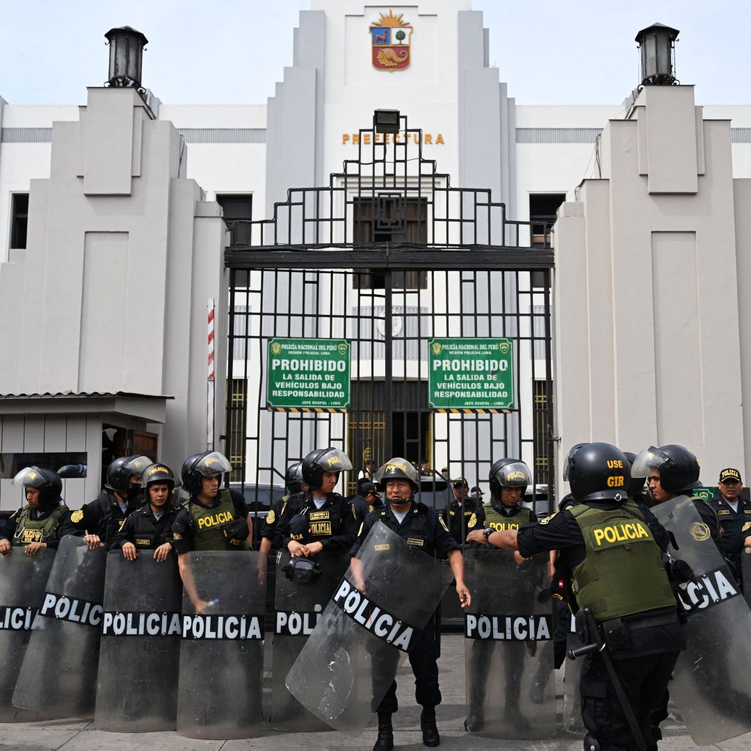 Police officers stand guard outside the Lima Prefecture, where Peruvian President Pedro Castillo was detained after he tried to dissolve Congress, in Lima on Dec. 7, 2022. 