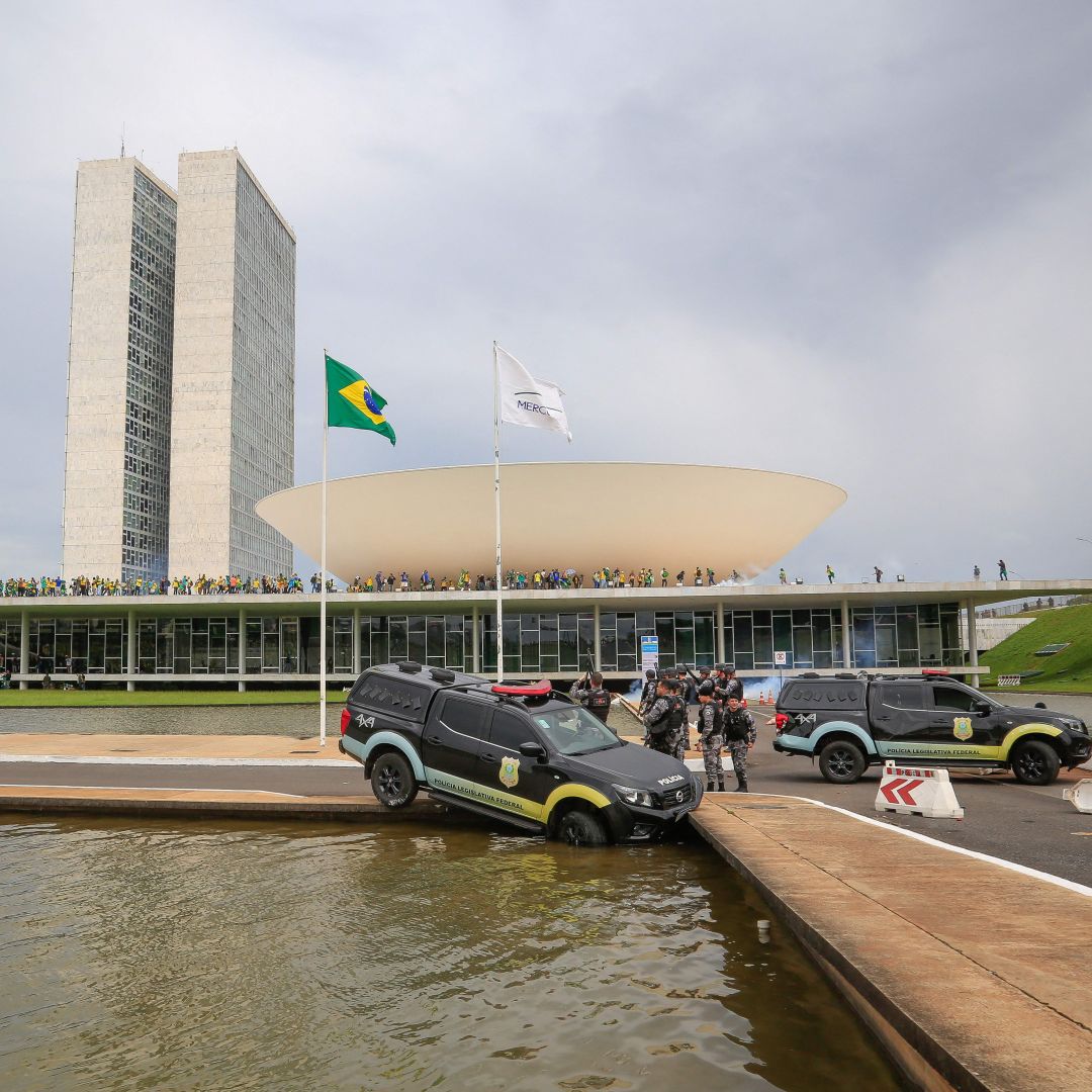Members of Brazil’s Federal Legislative Police stand next to a vehicle that crashed into a fountain as supporters of former President Jair Bolsonaro invade the National Congress in Brasilia on Jan. 8, 2023. 