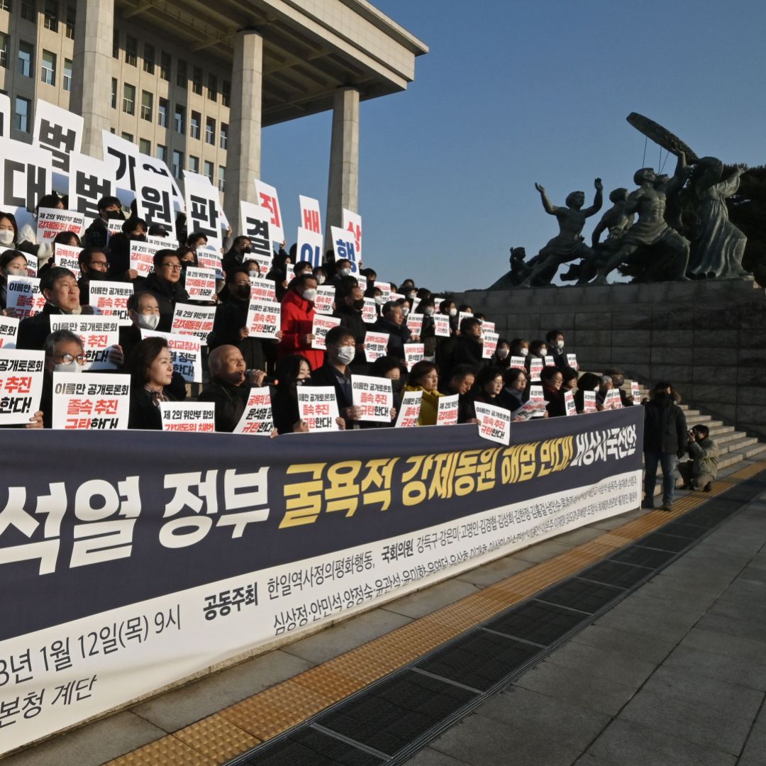 South Korean opposition lawmakers and supporters of the victims of Japan's wartime forced labor hold up placards during a protest against a public hearing on the issue at the National Assembly in Seoul on Jan. 12, 2023. South Korean opposition lawmakers and supporters of the victims of Japan's wartime forced labor hold up placards during a protest against a public hearing on the issue at the National Assembly in Seoul on Jan. 12, 2023.