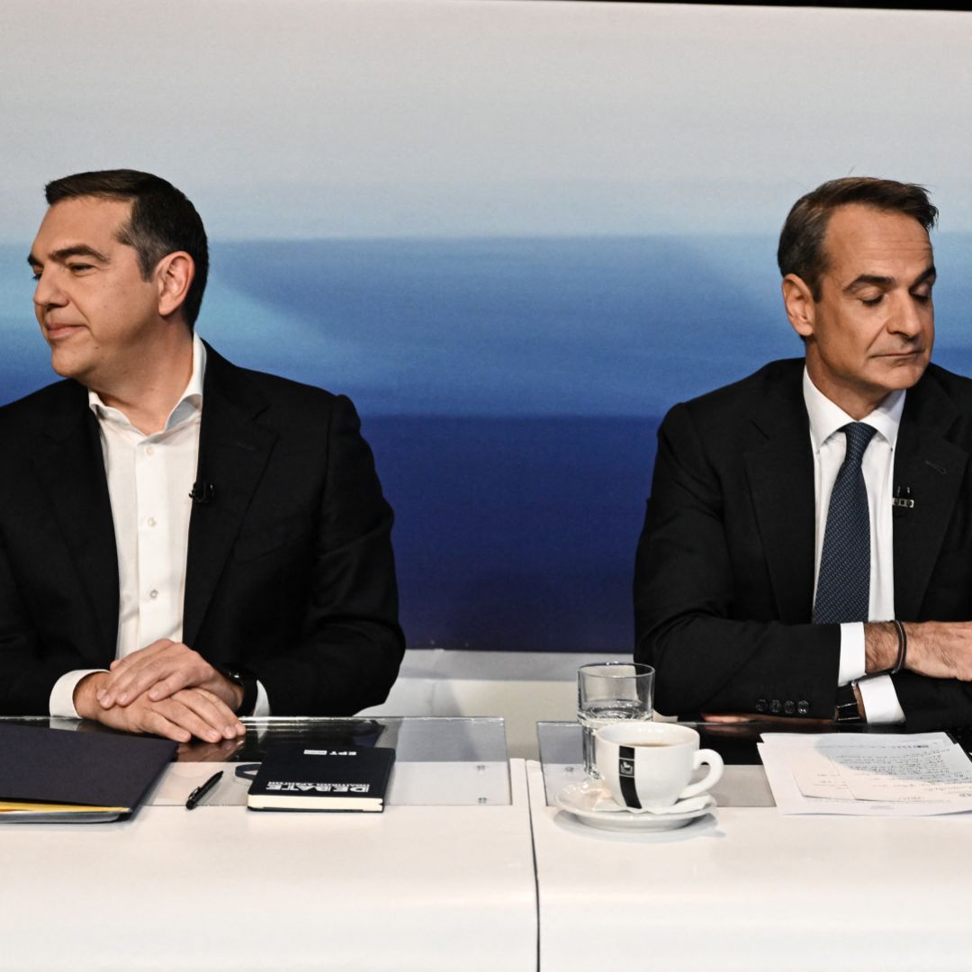 Alexis Tsipras (left), who leads the left-wing Syriza party, and Greek Prime Minister Kyriakos Mitsotakis (right), who leads the right-wing New Democracy party, look in opposite directions during a televised debate in Athens on May 10, 2023. 