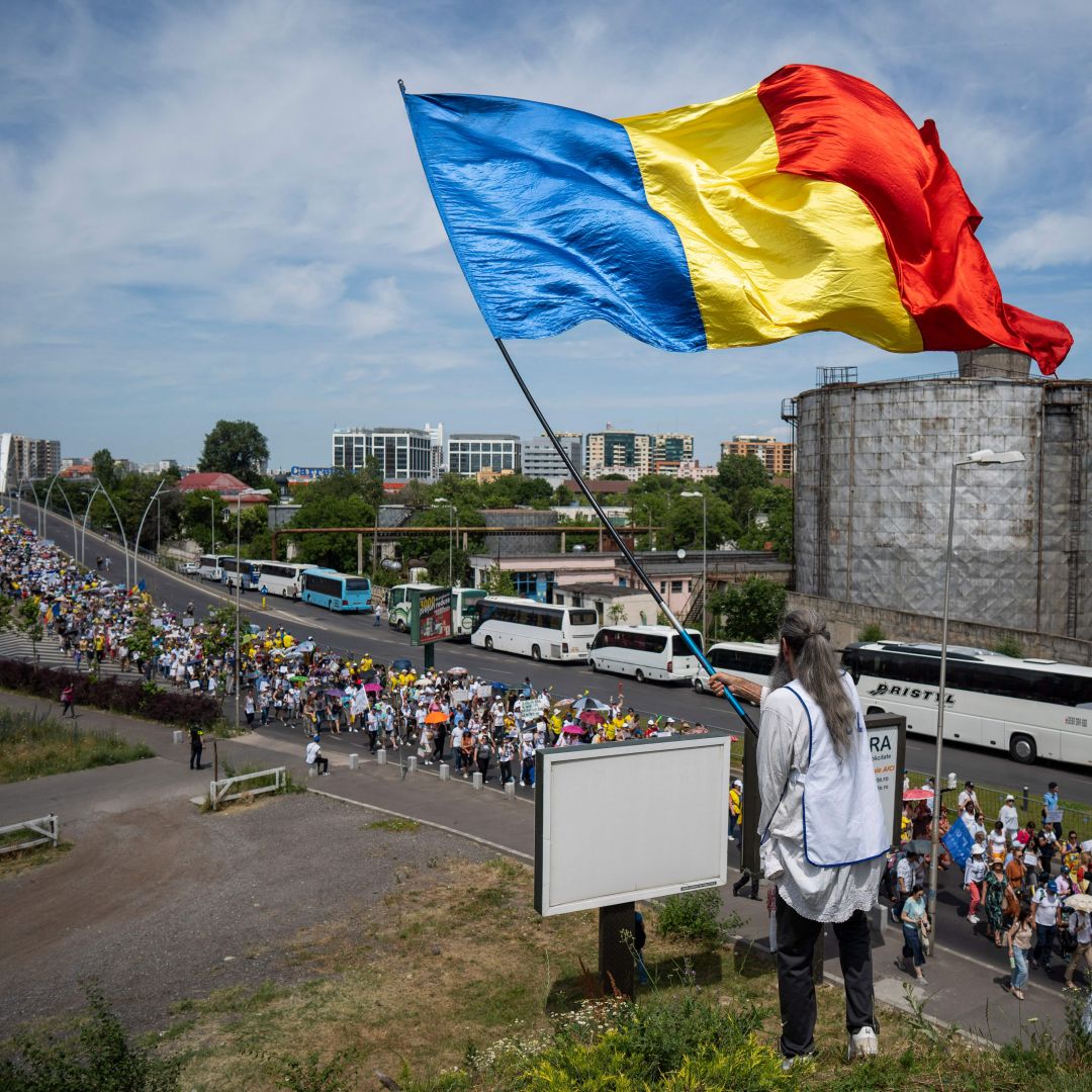 The Romanian flag is waved above a teachers' protest in Bucharest, Romania, on June 9, 2023. 