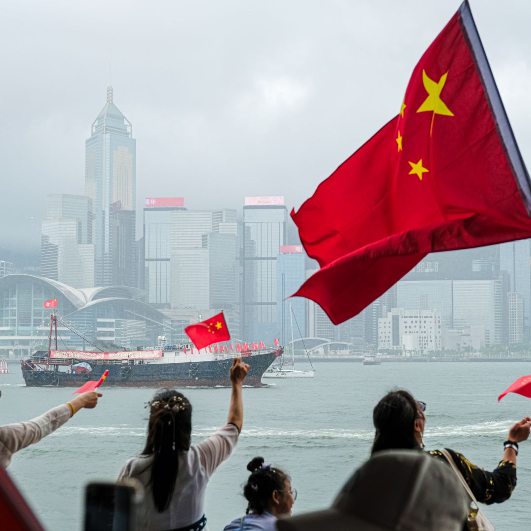 People in Hong Kong wave Chinese flags in celebration of the 26th anniversary of Hong Kong's handover from Britain to China on July 1, 2023. 