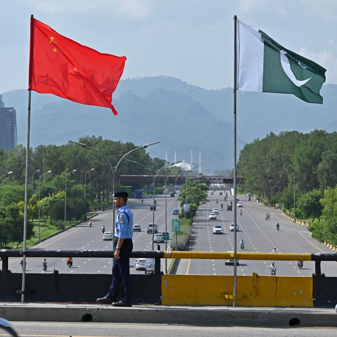 A policeman stands under Chinese and Pakistani flags along a road in Islamabad ahead of Chinese Vice Premier He Lifeng's visit on July 30, 2023.