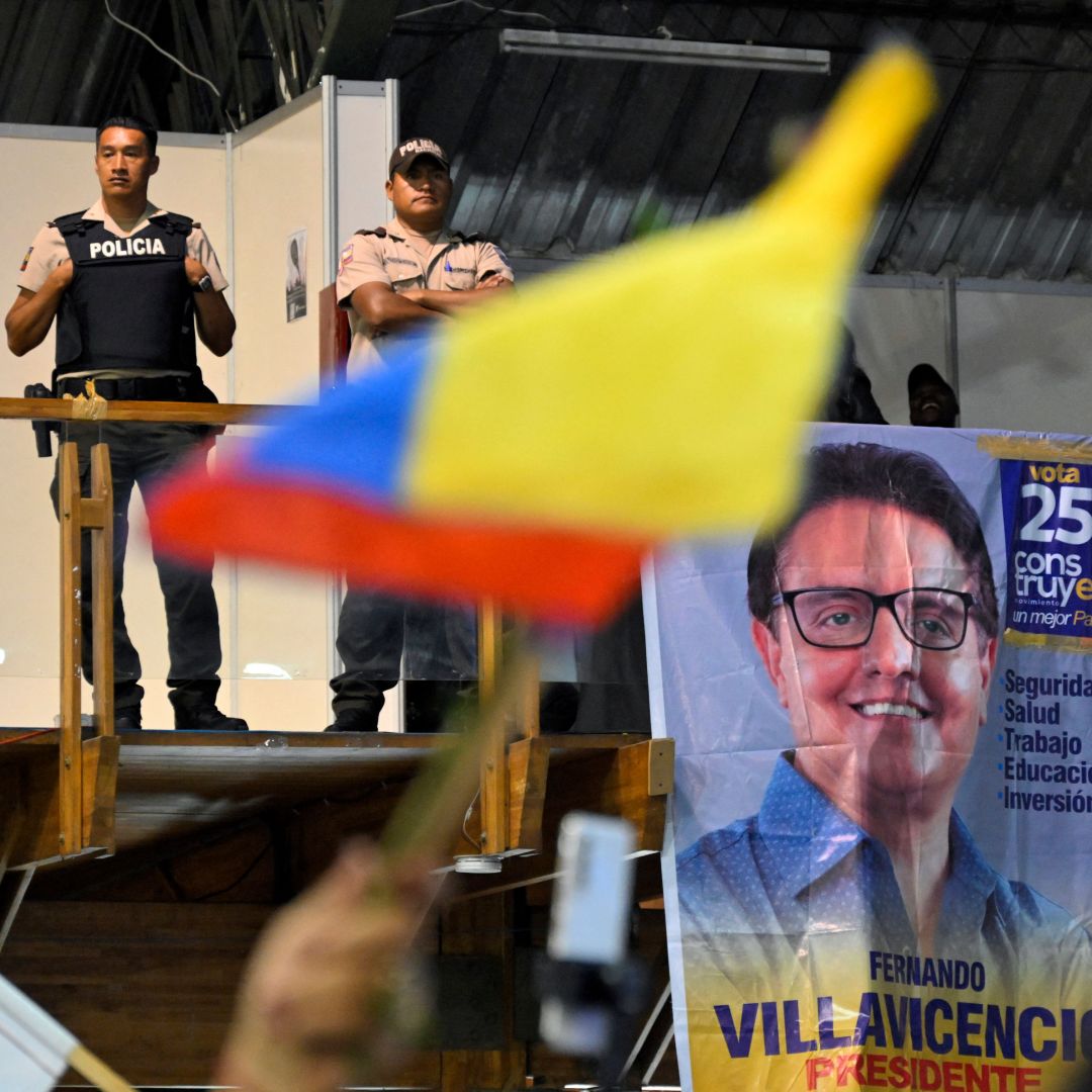 Policemen stand guard while supporters of slain Ecuadorian presidential candidate Fernando Villavicencio pay their respects at the Quito Exhibition Center in Quito, Ecuador, on Aug. 11, 2023. 