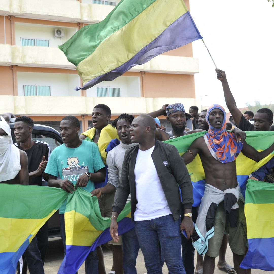 People holding Gabon national flags celebrate in Libreville on August 30, 2023, after a group of military officers announced they were ''putting an end'' to President Ali Bongo Ondimba's regime. 